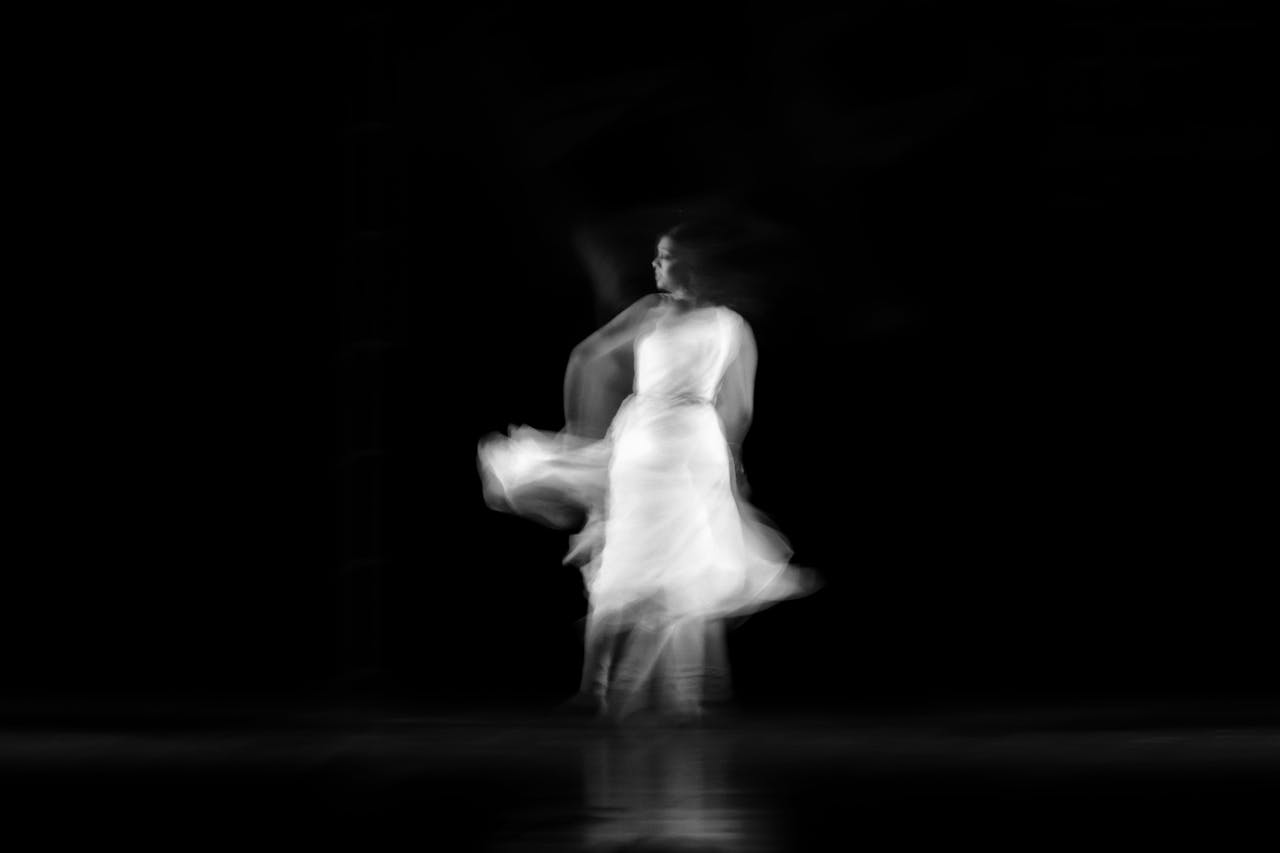 portfolio-01 Black and white photo of a ballet dancer twirling in motion blur against a dark background.