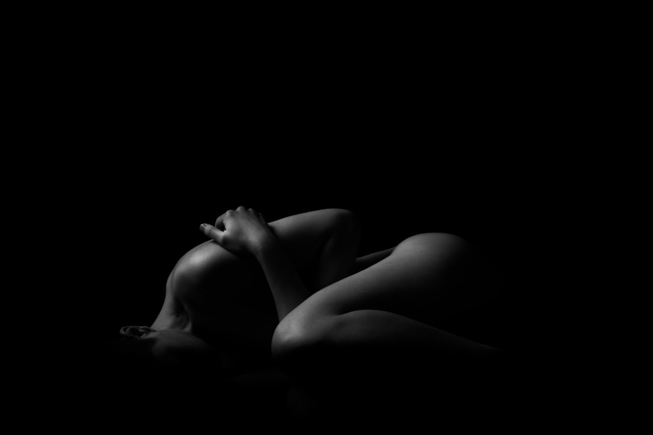about-01 Artistic black and white nude photograph featuring a silhouette of a woman in a studio.